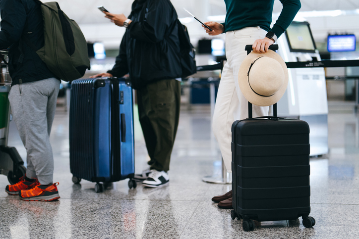 Credit: d3sign/Getty Images. People standing in line at an airport.