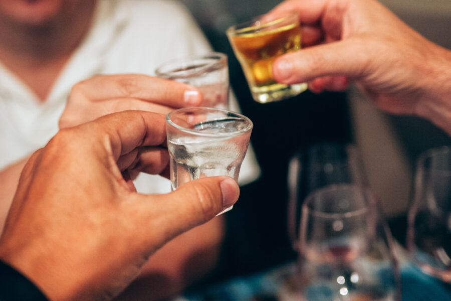 Credit: Peter Cade/GettyImages. Three people making a toast with grape liqueur shots